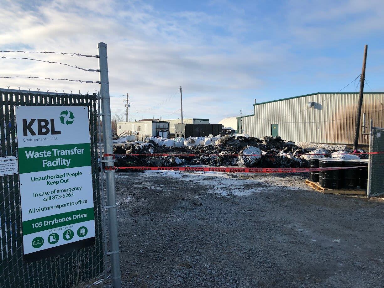Ash and burned waste piled in the yard at KBL Environmental's Yellowknife waste transfer facility, after a fire Monday night. (Luke Carroll/CBC - image credit)