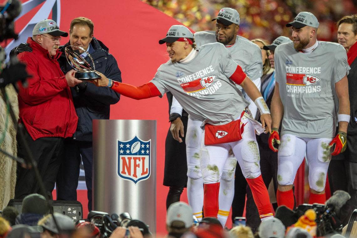 Kansas City Chiefs quarterback Patrick Mahomes hands over the Lamar Hunt Trophy to head coach Andy Reid after winning the AFC Championship Game against the Cincinnati Bengals Sunday at GEHA Field at Arrowhead Stadium.