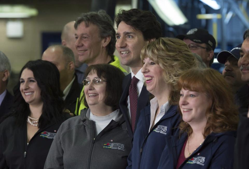 Prime Minister Justin Trudeau poses with employees of the Sault Ste. Marie transit system following an announcement at a bus depot in Sault Ste. Marie, Ont., on Friday, April 8, 2016. THE CANADIAN PRESS/Adrian Wyld