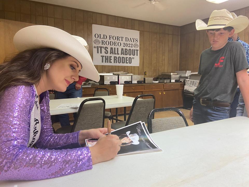 Molly Musick, Miss Rodeo Arkansas 2022 signs an autograph for a fan after family night on June 1 at the Old Fort Days Rodeo.