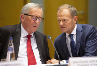 European Commission President Jean-Claude Juncker, left, and European Council President Donald Tusk, right, speak with each other during a tripartite summit in Brussels, Wednesday, Oct. 16, 2019. European Union and British negotiators have failed to get a breakthrough in the Brexit talks during a frantic all-night session and will continue seeking a compromise on the eve of Thursday's crucial EU summit. (AP Photo/Virginia Mayo)