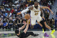Los Angeles Lakers forward LeBron James (23) moves to steal the ball from fallen New Orleans Pelicans forward Larry Nance Jr. in the second half of an NBA basketball game in New Orleans, Sunday, April 14, 2024. The Lakers won 124-108. (AP Photo/Gerald Herbert)