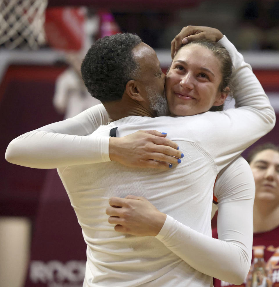 Virginia Tech's Elizabeth Kitley, right, and head coach Kenny Brooks, left, embrace during a special senior day presentation ceremony prior to an NCAA college basketball game against North Carolina in Blacksburg, Va., Sunday, Feb. 25, 2024. (Matt Gentry/The Roanoke Times via AP)