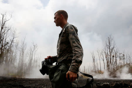 Senior Airman John Linzmeier of the Hawaii National Guard documents damage in Leilani Estates during ongoing eruptions of the Kilauea Volcano in Hawaii, U.S., May 18, 2018. REUTERS/Terray Sylvester