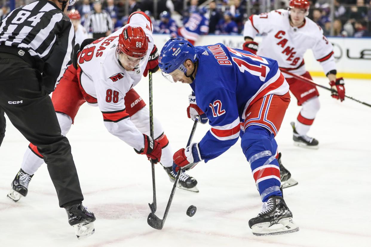 Nov 2, 2023; New York, New York, USA; Carolina Hurricanes center Martin Necas (88) and New York Rangers center Nick Bonino (12) battle for the puck during a face-off in the third period at Madison Square Garden.
