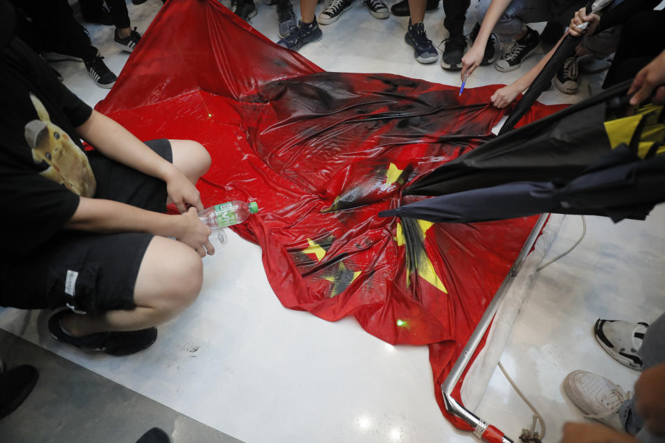 Protesters vandalize a Chinese national flag during a protest at a mall Sunday, Sept. 22, 2019, in Hong Kong. Hong Kong's pro-democracy protests, now in their fourth month, have often descended into violence in the evenings. A hardcore group of the protesters says the extreme actions are needed to get the government's attention. (AP Photo/Kin Cheung)
