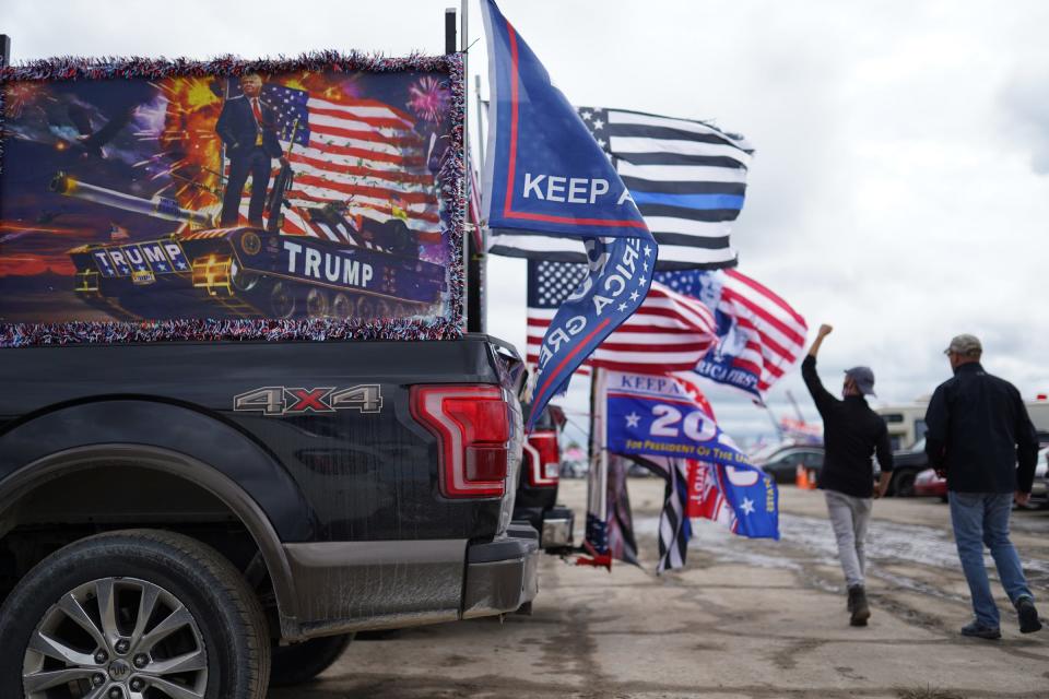 Flags fly on the back of trucks while waiting to hear President Donald Trump speak during a campaign stop at Avflight Saginaw in Freeland on Thursday, September 10, 2020.