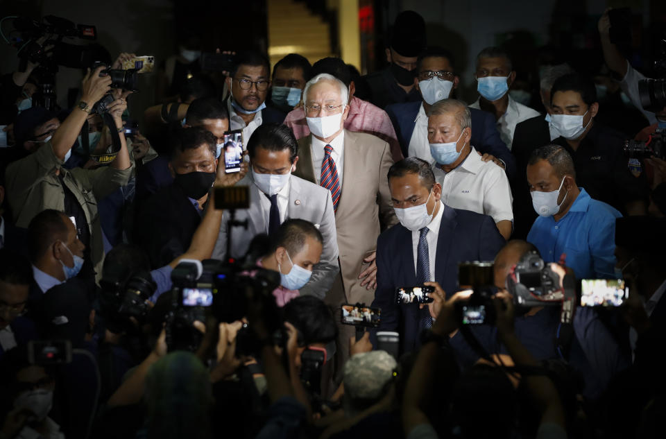 FILE - Former Malaysian Prime Minister Najib Razak, center, leaves a court house in Kuala Lumpur, Malaysia on July 28, 2020. Malaysia's Pardons Board said Friday, Feb. 2, 2024, it has reduced ex-Prime Minister Najib Razak's 12-year jail sentence by half and sharply cut the fine imposed after his corruption conviction. (AP Photo/Vincent Thian, File)