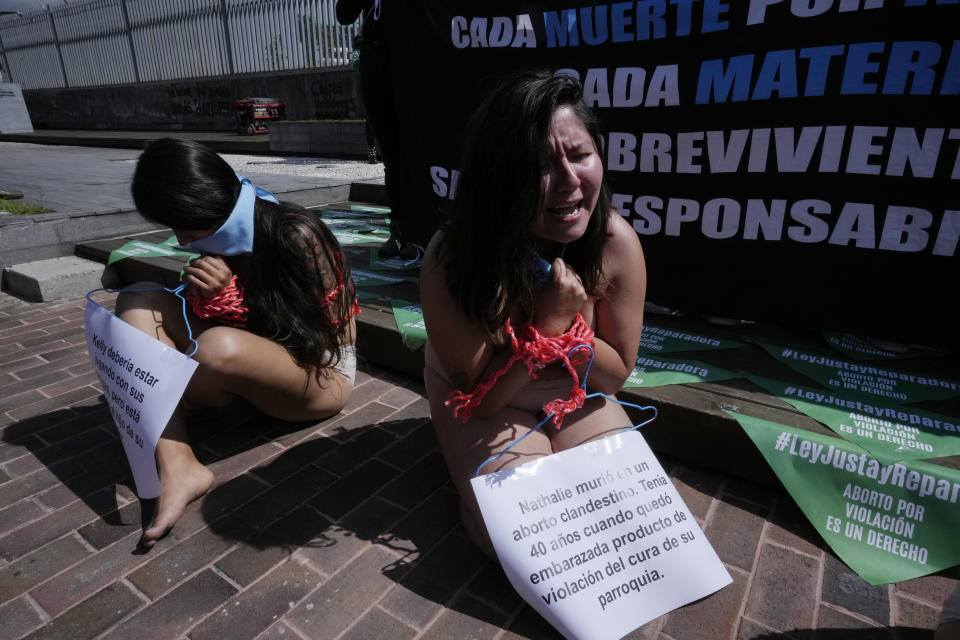 Abortion-rights activists sit gagged and bound during a demonstration outside the National Assembly as lawmakers vote on whether to allow abortion in all cases of rape, in Quito, Ecuador, Thursday, Feb. 17, 2022. Currently, abortion is legal in Ecuador if the mother’s life is in danger or in cases involving the rape of a woman with a mental disability. (AP Photo/Dolores Ochoa)