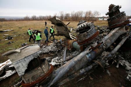 Dutch investigators and an Emergencies Ministry member work at the site where the downed Malaysia Airlines flight MH17 crashed, near the village of Hrabove (Grabovo) in Donetsk region, eastern Ukraine November 16, 2014. REUTERS/Maxim Zmeyev