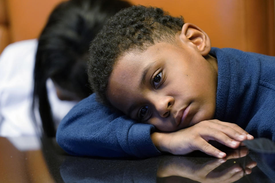 In this Sept. 23, 2021, photo Jhaimarion, 10, reacts as he listens to his mother, Krystal Archie talking with an Associated Press reporter in Chicago. Archie’s three children were present when police, on two occasions, just 11 weeks apart, kicked open her front door and tore through their home searching for drug suspects. She’d never heard of the people they were hunting. Her oldest child, Savannah was 14 at the time; her youngest, Jhaimarion, was seven. They were ordered to get down on the floor. (AP Photo/Nam Y. Huh)