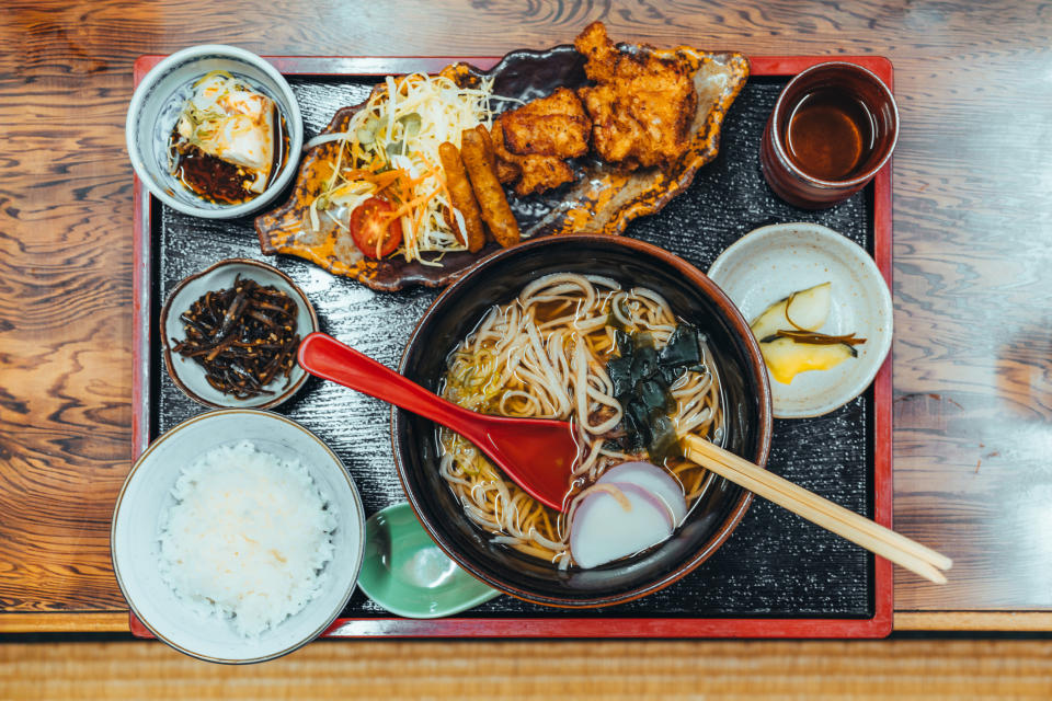 Japanese meal with noodles, rice, fried chicken, and sides on a tray