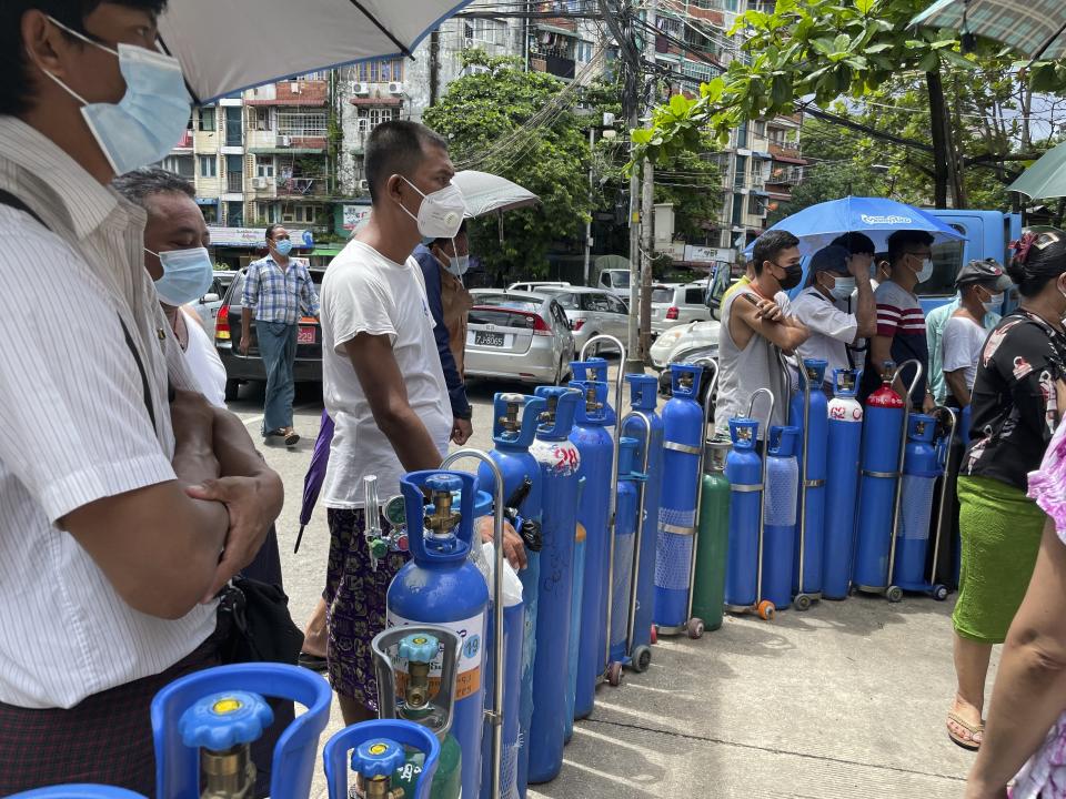 People queue up with their oxygen tanks outside an oxygen refill station in Pazundaung township in Yangon, Myanmar, Sunday, July 11, 2021. Myanmar is facing a rapid rise in COVID-19 patients and a shortage of oxygen supplies just as the country is consumed by a bitter and violent political struggle since the military seized power in February. (AP Photo)