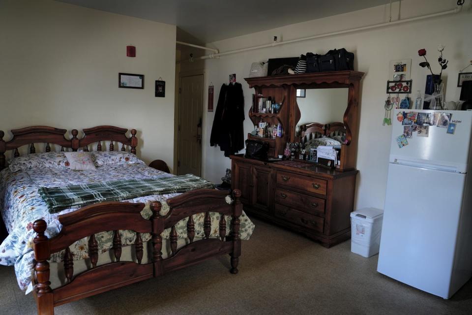 One resident's room at 233 High St. The rooming house provides secondhand furniture, a compact refrigerator and often a television, and Wi-Fi, cable and utilities are included in the rent, $650 a month for new tenants.