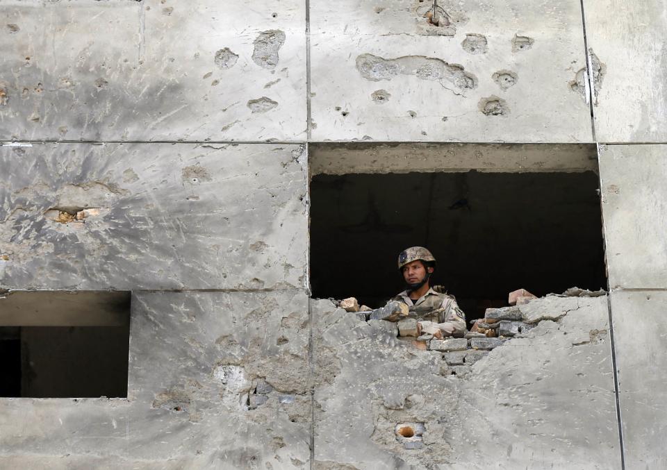 Afghan security personnel looks out from a building at the site of an attack, north of Kabul International Airport in Kabul