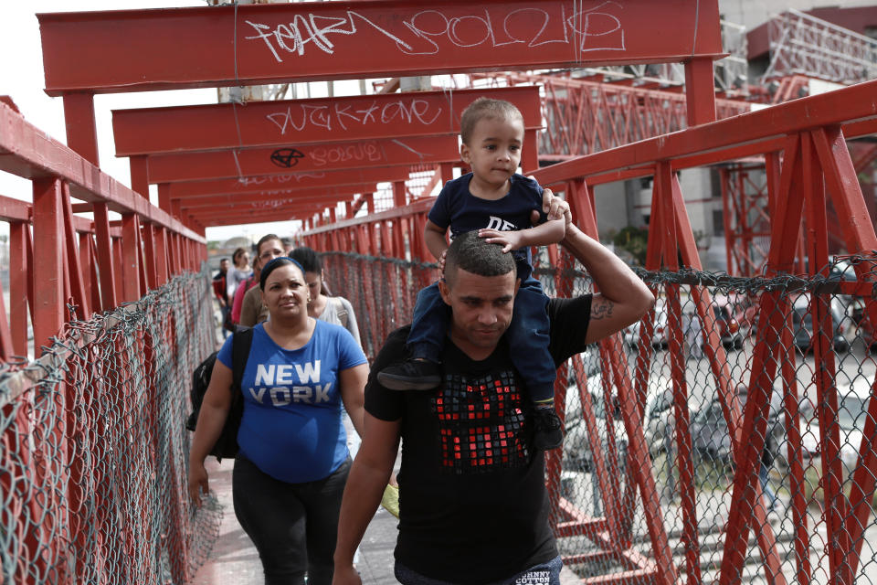FILE - In this April 29, 2019, file photo, Cuban migrants are escorted in Ciudad Juarez, Mexico, by Mexican immigration officials as they cross the Paso del Norte International bridge to be processed as asylum seekers on the U.S. side of the border. Newly unsealed court documents show that many U.S. holding cells along the Mexican border were less than half-full, or even empty, during an unprecedented surge of asylum-seeking Central American families. The documents cast doubt on the Trump administration's claims that people had to wait in Mexico because there weren't enough resources to accommodate them. (AP Photo/Christian Torres, File)