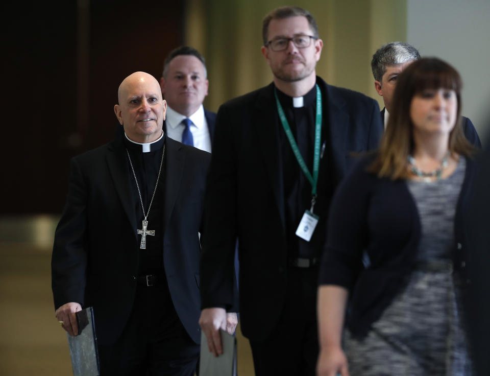 Samuel Aquila, archbishop of the Denver diocese of the Roman Catholic Church, left, trails Very Rev. Randy Dollins, vicar general, at which a plan was revealed to have a former federal prosecutor review the sexual abuse files of Colorado's Roman Catholic dioceses at a news conference Tuesday, Feb. 19, 2019, in Denver. The church will pay reparations to victims under a voluntary joint effort with the state attorney general. (AP Photo/David Zalubowski)