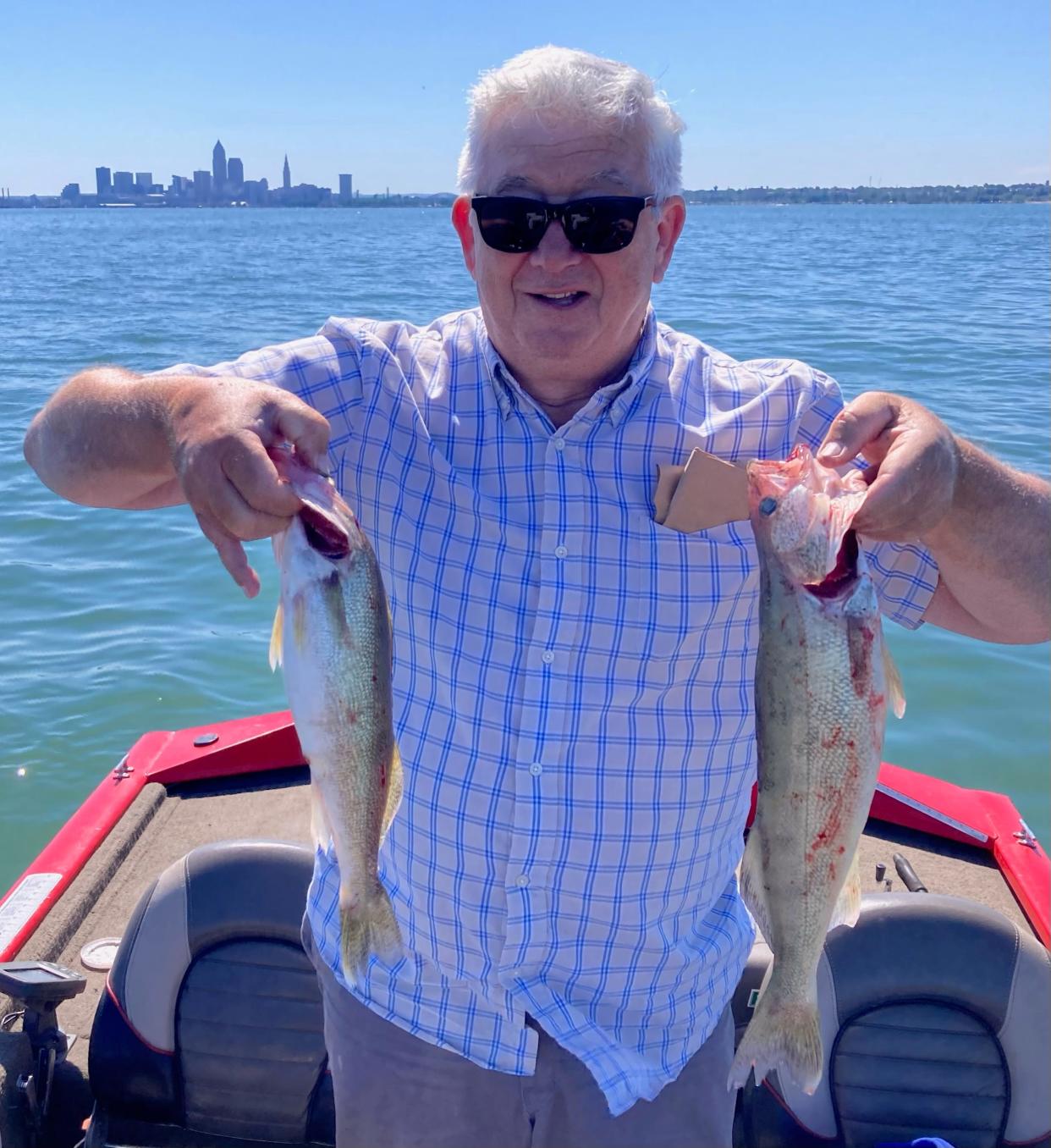 With the Cleveland skyline in the background, Bob Yurich, of Doylestown, shows off a some of the walleye he caught on a recent trip to Lake Erie. The walleye bite is hot on the big pond, with limit catches nearly every time out.