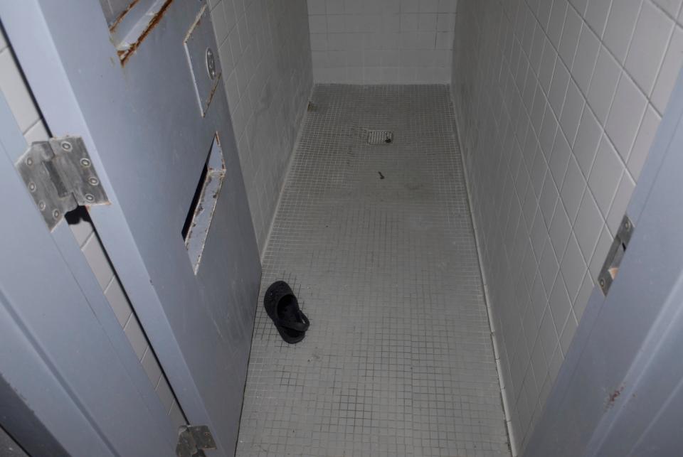 A photograph of a prison shower cell