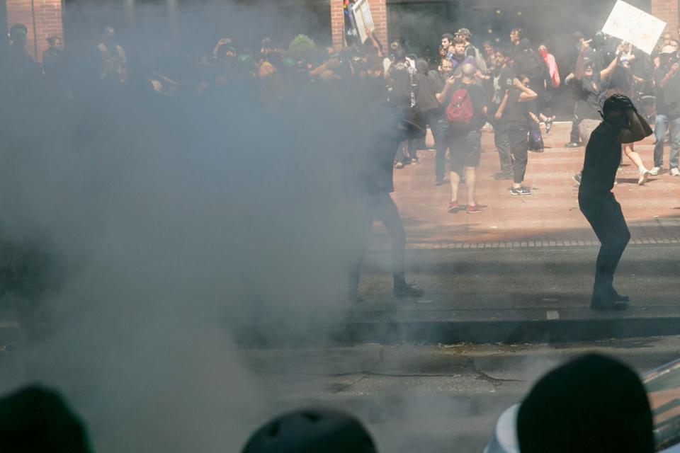 Police push protesters back with tear gas and flash-bang grenades during a rally in Portland, Oregon, Saturday, Aug. 4, 2018. Small scuffles broke out as police deployed "flash bang" devices and other means to disperse hundreds of right-wing and self-described anti-fascist protesters.