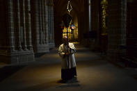 A priest walks during a Stations of the Cross, in an empty Santa Maria Cathedral during Good Friday after celebrations and services were cancelled due to the outbreak of coronavirus, in Pamplona, northern Spain, Friday, April 10, 2020. COVID-19 causes mild or moderate symptoms for most people, but for some, especially older adults and people with existing health problems, it can cause more severe illness or death. (AP Photo/Alvaro Barrientos)