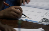 Felicity Brown, 9, uses a workbook to practice math with her parents and siblings at home in Austin, Texas, on Tuesday, July 13, 2021. After homeschooling during the pandemic, the Brown family has switched to homeschooling their kids permanently using a Catholic-based curriculum and won't be sending them back to in-person schools in the fall. (AP Photo/Eric Gay)