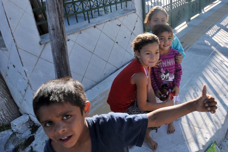 Roma children play in a Roma settlement in Farsala, central Greece, on October 19, 2013