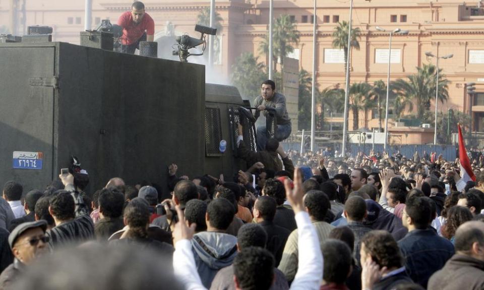 Protesters climb on to a water cannon during a anti-government protest on 25 January 2011.