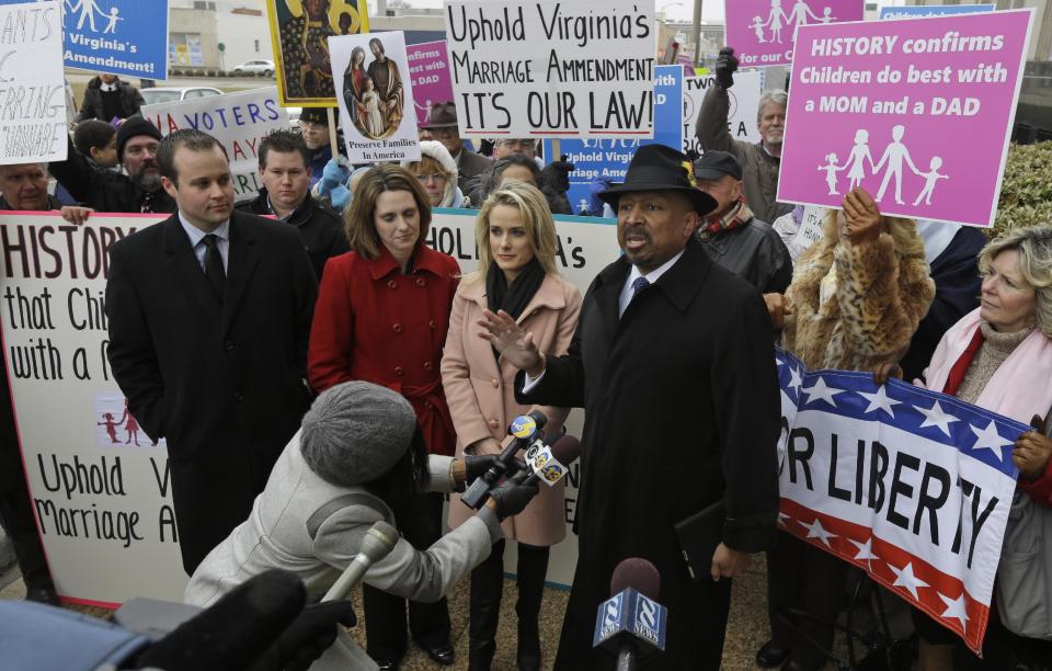 Former Republican lieutenant governor candidate E.W. Jackson, front right, speaks to the media during a demonstration outside federal court in Norfolk, Va., Tuesday, Feb. 4, 2014. Jackson spoke in favor of the law banning same-sex marriage. A federal judge will hear arguments Tuesday on whether Virginia's ban on gay marriage is unconstitutional. The state's newly elected Democratic attorney general has already decided to side with the plaintiffs and will not defend the ban. (AP Photo/Steve Helber)