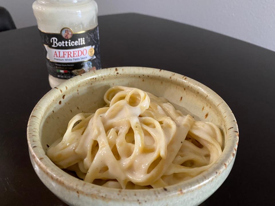 Alfredo in a bowl with Botticelli Alfredo sauce jar in background