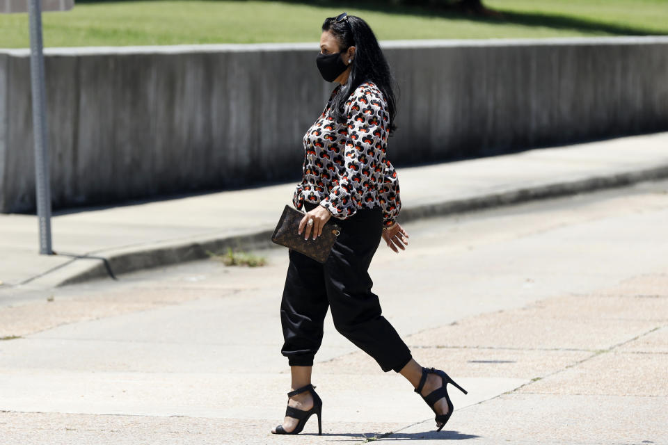 Iris Villalon, 44, of Ocean Springs, crosses the street as she heads for the Thad Cochran United States Courthouse in Jackson, Miss., Thursday, Aug. 6, 2020, for an arraignment hearing in federal court on immigration crimes and other federal charges stemming from the largest single-state worksite enforcement action last year at a number of Mississippi poultry processing plants. (AP Photo/Rogelio V. Solis)