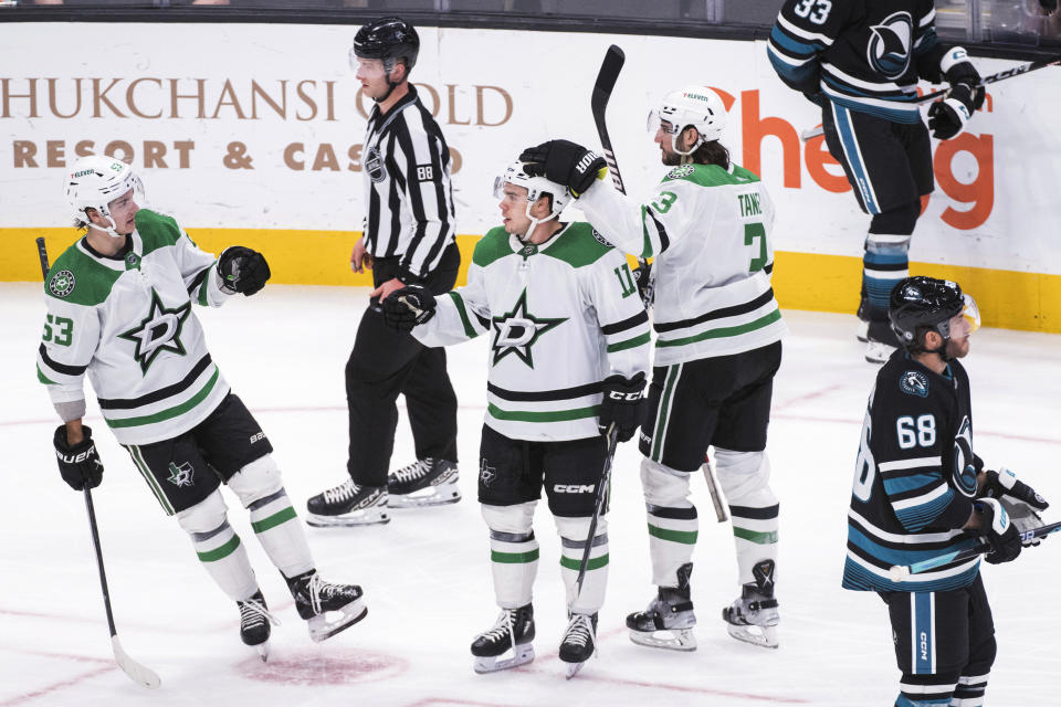 Dallas Stars defenseman Christopher Tanev (3) and center Wyatt Johnston (53) celebrate with center Logan Stankoven (11) after his goal against the San Jose Sharks during the third period of an NHL hockey game Tuesday, March 5, 2024, in San Jose, Calif. (AP Photo/Nic Coury)