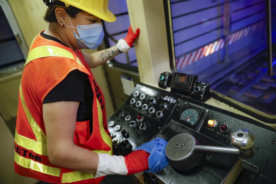 A contractor cleans a subway car at the 96th Street station to control the spread of COVID-19, Thursday, July 2, 2020, in New York. Mass transit systems around the world have taken unprecedented — and expensive — steps to curb the spread of the coronavirus, including shutting down New York subways overnight and testing powerful ultraviolet lamps to disinfect seats, poles and floors. (AP Photo/John Minchillo)