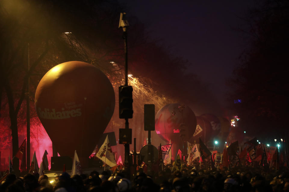 People march during a demonstration in Paris, Thursday, Dec. 5, 2019. The Eiffel Tower shut down, France's high-speed trains stood still and tens of thousands of people marched through Paris and other cities Thursday, in a massive and sometimes chaotic outpouring of anger at the government's plan to overhaul the retirement system. (AP Photo/Thibault Camus)