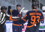 Edmonton Oilers' Connor McDavid (97) and Ryan Nugent-Hopkins (93) celebrate a goal against the Vancouver Canucks during second-period NHL hockey action in Edmonton, Alberta, Thursday, Jan. 14, 2021. (Jason Franson/The Canadian Press via AP)