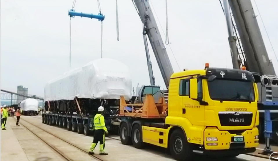 台鐵新購首批Ｒ二００型柴電機車二輛，由大型拖車運至台中港二號碼頭的台中港支線貨運鐵道。（記者陳金龍攝）