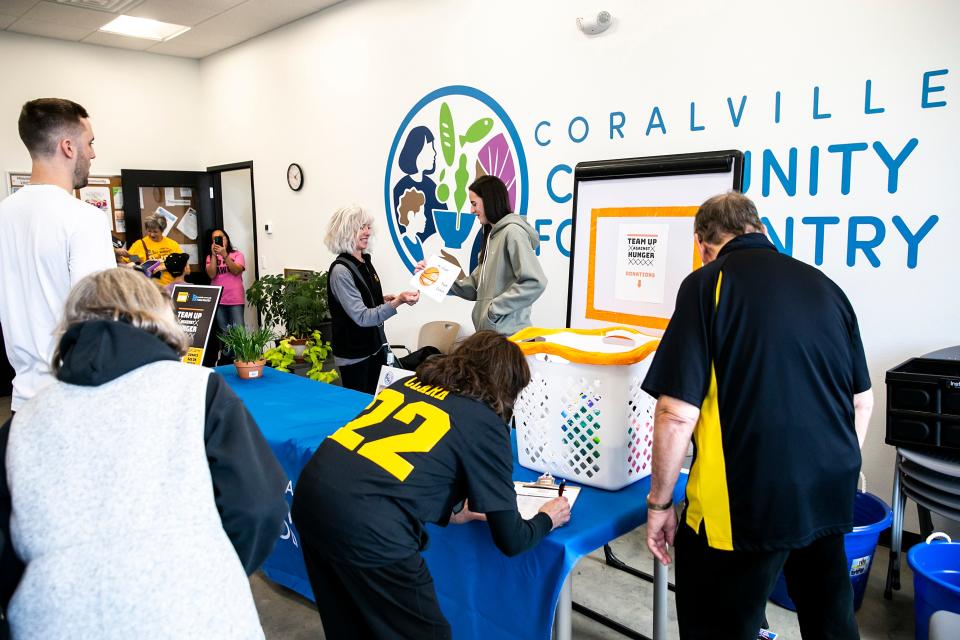 Iowa women's basketball guard Caitlin Clark talks with fans who donated to the Coralville Community Food Pantry, Friday, April 21 at 804 13th Avenue. Fans who donated at least $22 or brought health items could meet with Clark as part of the Team Up Against Hunger campaign. The food pantry opened its new location earlier this month.