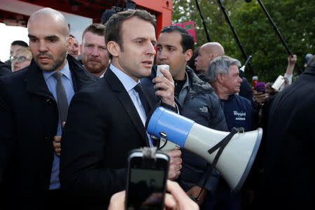 Emmanuel Macron, head of the political movement En Marche !, or Onwards !, and candidate for the 2017 French presidential election, uses a megaphone to talk to Whirlpool employees in front of the company plant in Amiens, France, April 26, 2017. REUTERS/Pascal Rossignol