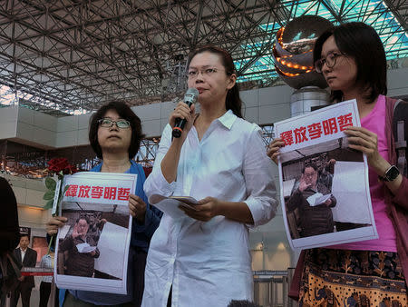 Li Ching-yu (C), a wife of Taiwanese human rights activist Li Ming-che, who is detained in China, speaks to media after she was rejected to board a plane to Beijing at Taoyuan International Airport, Taiwan April 10, 2017. REUTERS/Fabian Hamacher