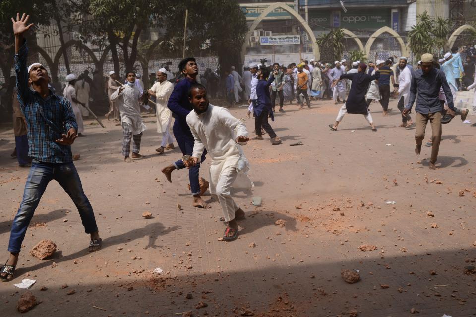 Two factions of protestors clash after Friday prayers at Baitul Mokarram mosque in Dhaka, Bangladesh, Friday, March 26, 2021. Witnesses said violent clashes broke out after one faction of protesters began waving their shoes as a sign of disrespect to Indian Prime Minister Narendra Modi, and another group tried to stop them. Local media said the protesters who tried to stop the shoe-waving are aligned with the ruling Awami League party. The party criticized the other protest faction for attempting to create chaos in the country during Modi’s visit. (AP Photo/Mahmud Hossain Opu)