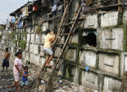 Residents climb into their houses atop gravestones inside a cemetery in Manila October 21, 2008. Many poor urban dwellers make their homes in public cemeteries, converting abandoned tombs and mausoleums into houses. The local government plan to move out the hundreds of people who live in the cemeteries around the city before the upcoming All Souls' Day, a day of remembrance for the dead when Catholics visit the graves of their relatives. REUTERS/Cheryl Ravelo (PHILIPPINES) - RTX9REV