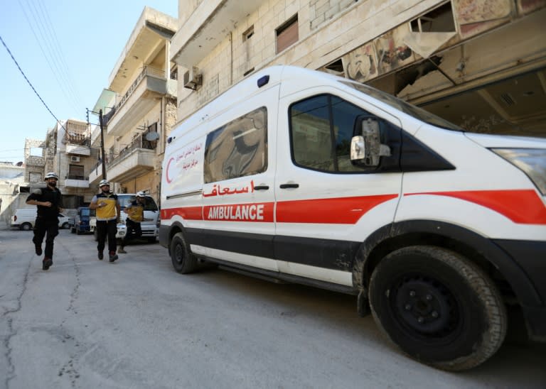 White Helmets rescuers rush to an ambulance after receiving an alert in the rebel-held northern Syrian city of Idlib on August 26, 2018