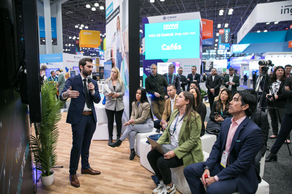 Attendees watch a product demonstration on the show floor at NRF 2024. Photo by Jason Dixson Photography.