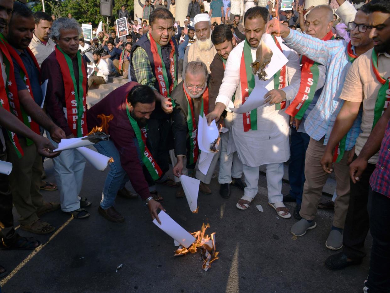 Members and activists shout slogans against the Indian government as they burn copies of the Citizenship Amendment Bill 2019: AFP via Getty Images