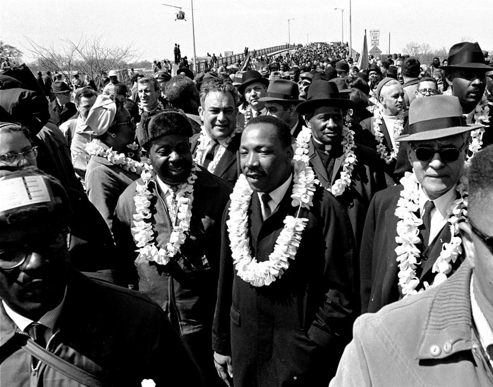 FILE - In this March 21, 1965 file photo, Martin Luther King, Jr. and his civil rights marchers cross the Edmund Pettus Bridge in Selma, Ala., heading for the capitol, Montgomery, during a five day, 50 mile walk to protest voting laws. The annual celebration of the Martin Luther King Jr. holiday in his hometown in Atlanta is calling for renewed dedication to nonviolence following a turbulent year. The slain civil rights leader's daughter, the Rev. Bernice King, said in an online church service Monday, Jan. 18, 2021, that physical violence and hateful speech are “out of control” in the aftermath of a divisive election followed by a deadly siege on the U.S. Capitol in Washington by supporters of President Donald Trump. (AP Photo/File)