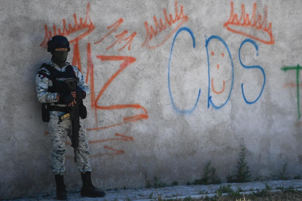 A Mexican soldier stands guard next to some graffitis of the drug trafficker Mayo Zambada (MZ) and the criminal group “Cartel de Sinaloa” (CDS), in Palmas Altas village, Jerez de Garcia Salinas municipality, Zacatecas state, Mexico (AFP via Getty Images)