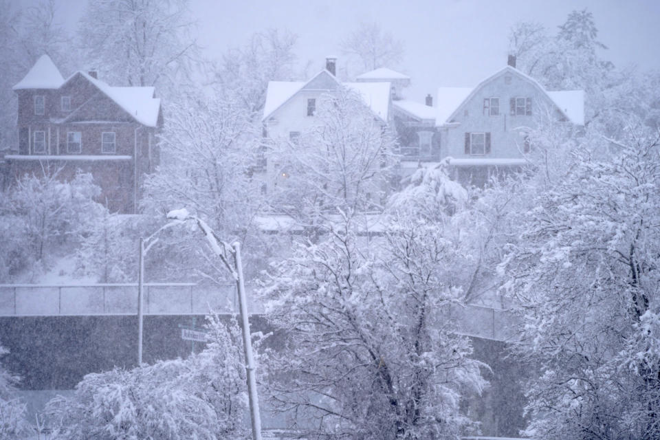 Homes and trees are covered with snow, Tuesday, March 14, 2023, in Pittsfield, Mass. The New England states and parts of New York are bracing for a winter storm due to last into Wednesday. (Ben Garver/The Berkshire Eagle via AP)