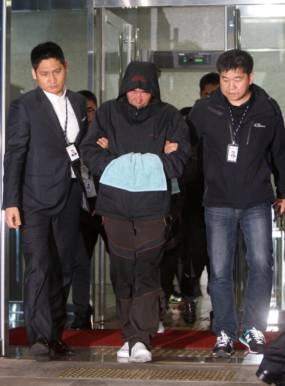 Lee Joon-seok, center, the captain of the sunken ferry Sewol in the water off the southern coast, leaves a court which issued his arrest warrant in Mokpo, south of Seoul, South Korea, Saturday, April 19, 2014. The investigation into South Korea's ferry disaster focused on the sharp turn it took just before it began listing and on the possibility that a quicker evacuation order by the captain could have saved lives, officials said Friday, as rescuers struggled to find some 270 people still missing and feared dead. (AP Photo/Yonhap) KOREA OUT