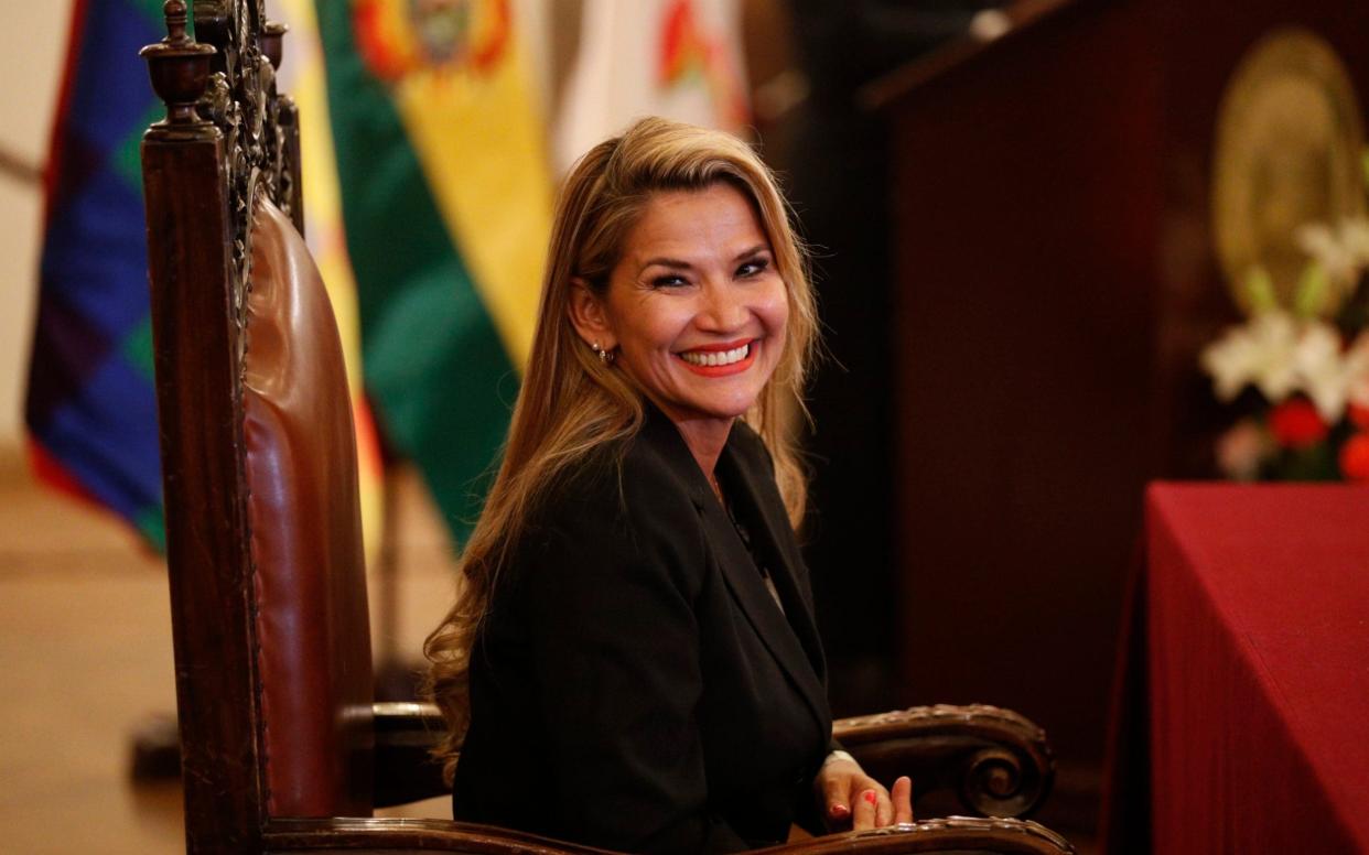 Jeanine Anez smiles during a swearing-in ceremony of her new cabinet at the presidential palace - AP