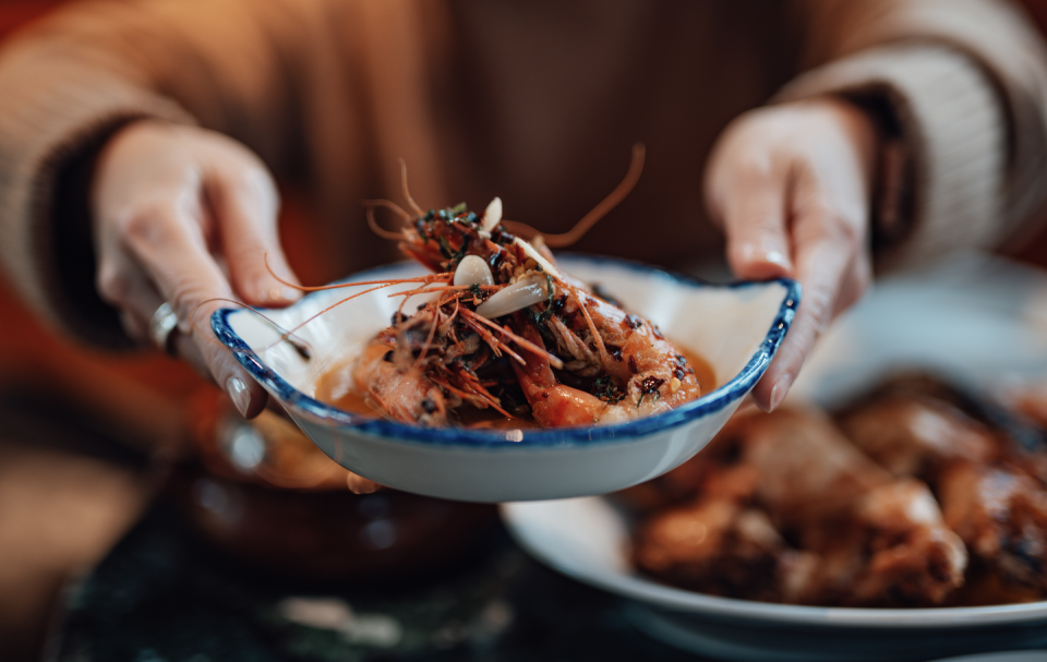 woman hands a plate of food